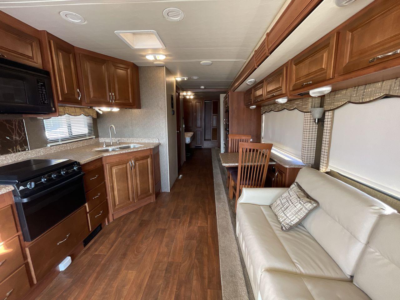 2014 BROWN HOLIDAY RAMBLER VACATIONER 33SFD - (1F66F5DY0D0) with an 6.8L V10 SOHC 30V engine, Length: 35 ft. | Slides: 2 transmission, located at 4319 N Main St, Cleburne, TX, 76033, (817) 678-5133, 32.385960, -97.391212 - The 2013 Holiday Rambler Vacationer 33SFD gives you the comfort and convenience of a residential home. The cockpit comes with a flat-screen TV above with lots of storage space. There is a comfy hide-a-bed sofa in the living area to have a comfortable view of the TV. Beside the couch is a free-standi - Photo #12