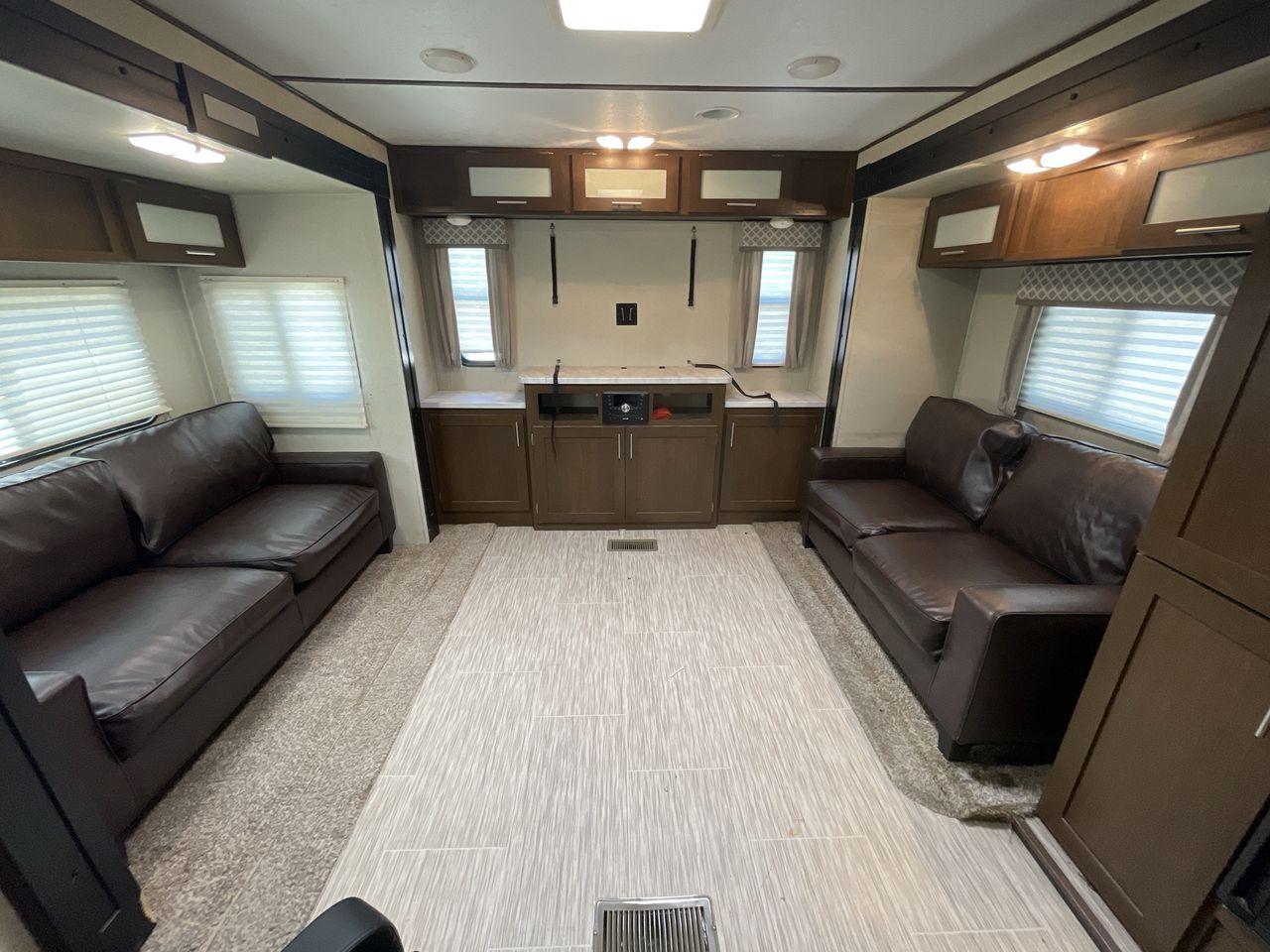 2019 TAN FOREST RIVER AVENGER 32DEN (5ZT2AVXB6KB) , Length: 37.92 ft. | Dry Weight: 7,989 lbs. | Slides: 2 transmission, located at 4319 N Main St, Cleburne, TX, 76033, (817) 678-5133, 32.385960, -97.391212 - Measuring an impressive 36 feet, this model unfolds to reveal two strategically placed slide-outs, creating a spacious haven for relaxation. The master bedroom welcomes you with a queen-size bed and ample storage, ensuring a peaceful retreat after a day of outdoor exploration. The living area is a h - Photo #11